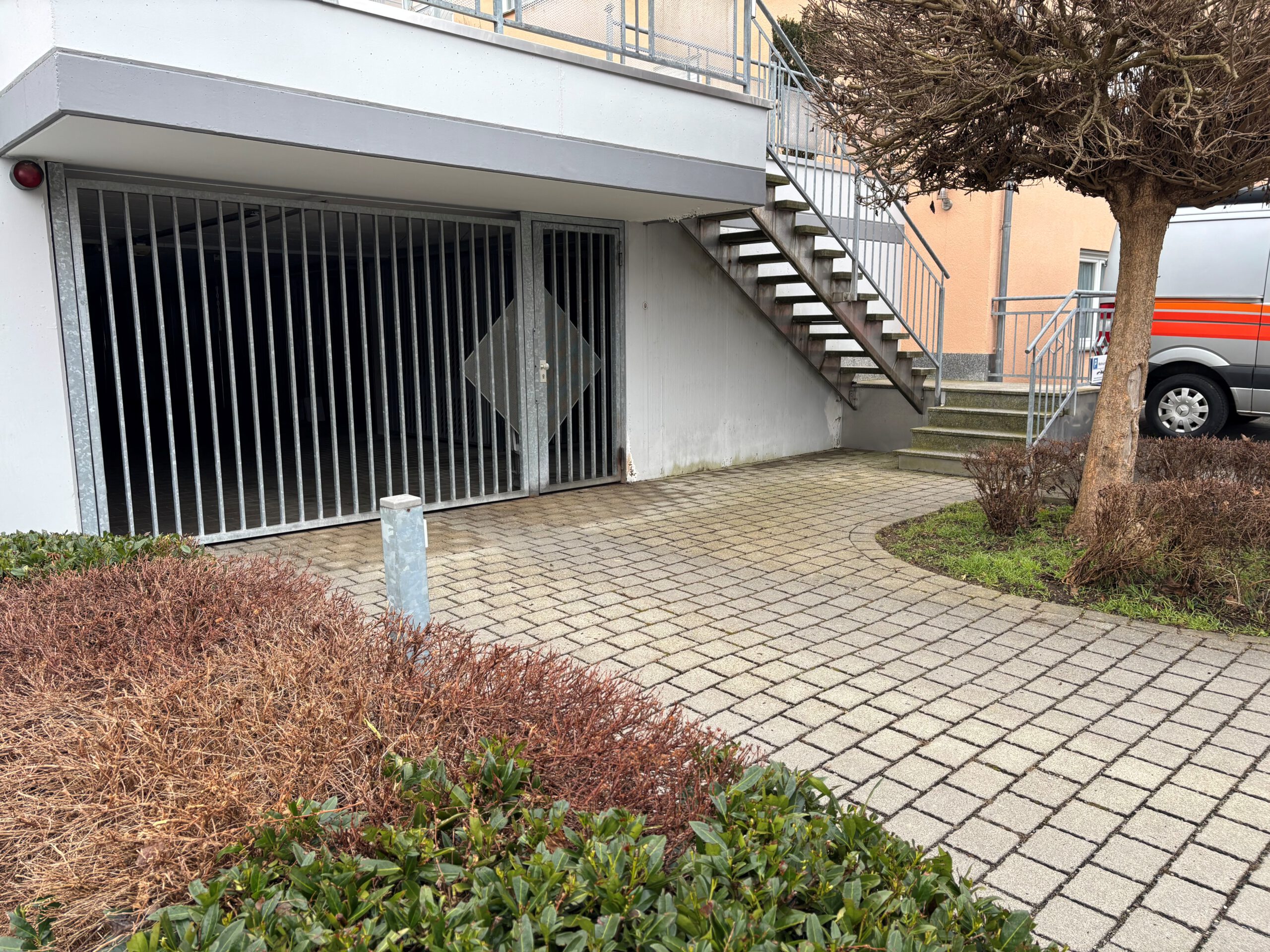 Ein Bild von einer Einfahrt auf dem ein Tiefgaragentor zu sehen ist.